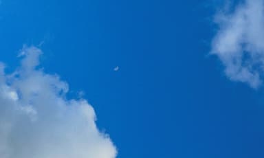 Photo of blue sky with clouds and the moon